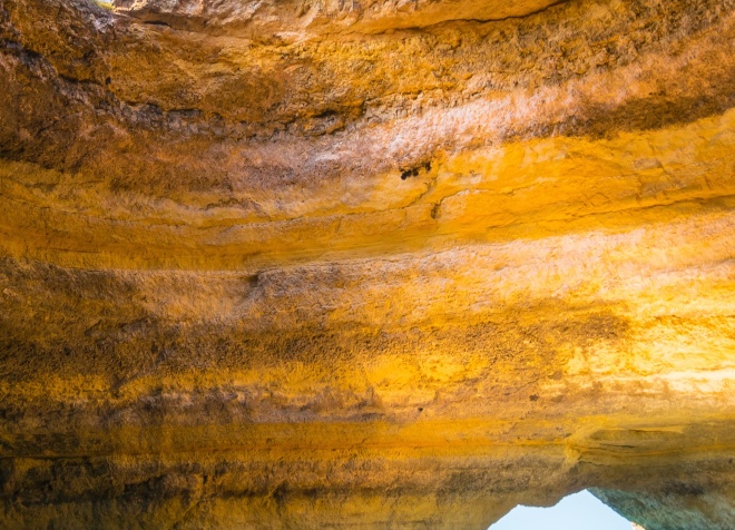 Person standing on rock overlooking Algarve coast